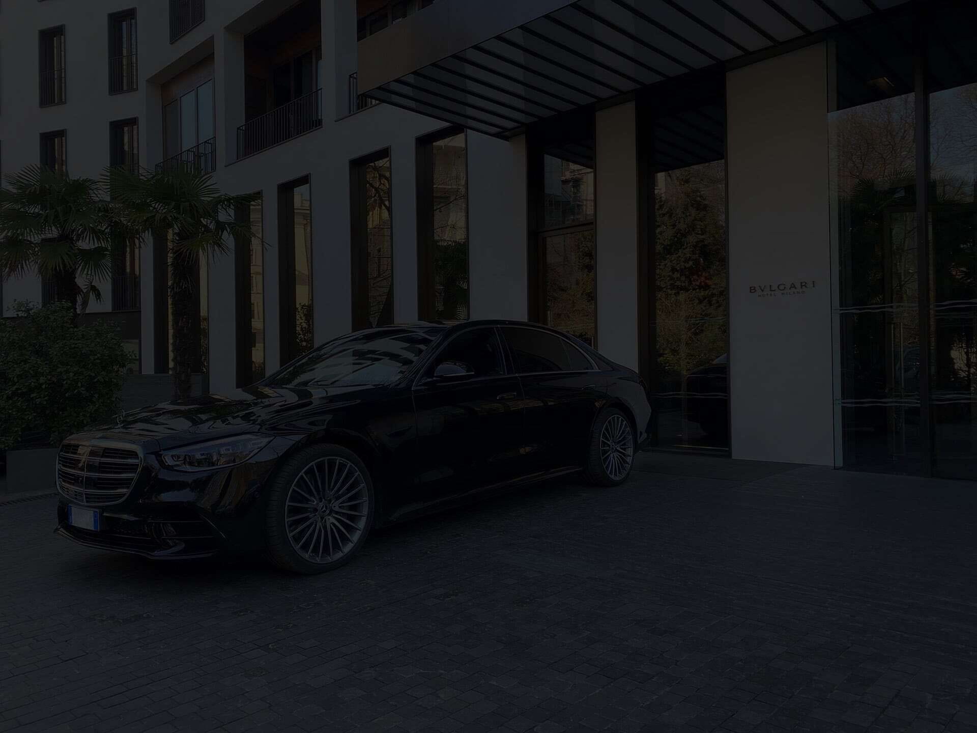 photo of a black Mercedes parked in front of a modern building.