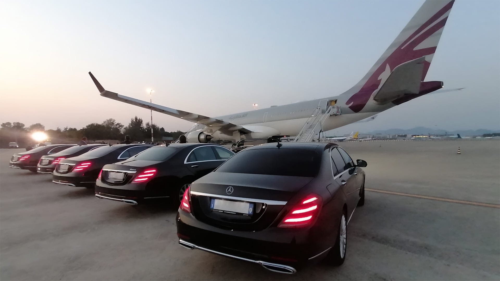 photo of a black Mercedes car parked in front of a modern building