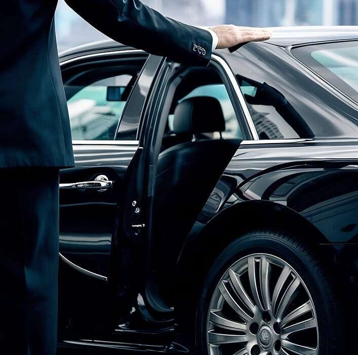 Photo of a driver opening the door of an executive car.